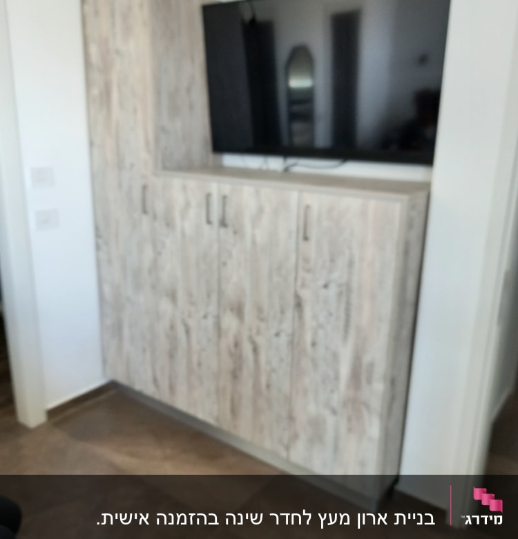 ארון עץ עם טלוויזיה תלויה מעליו
